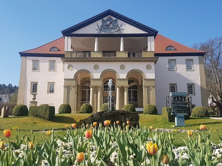 Schloss im April 2020 mit Blumen am sonnigen Tag mit blauem Himmel